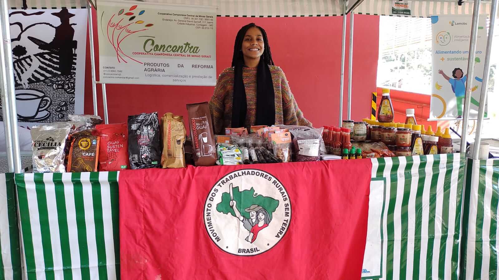 Imagem mostra mulher em banca com produtos da cooperativa CONCENTRA